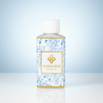 Flesje Wasgeurtje Blossom Drip wasparfum met blauw-wit bloemenpatroon op glanzend oppervlak, tegen een zachte lichtblauwe achtergrond.