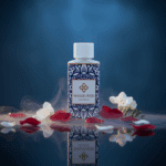 Flesje Wasgeurtje Full Moon wasparfum omringd door witte bloemen en rode bloemblaadjes, met nevel en reflectie op een donkere glanzende ondergrond.