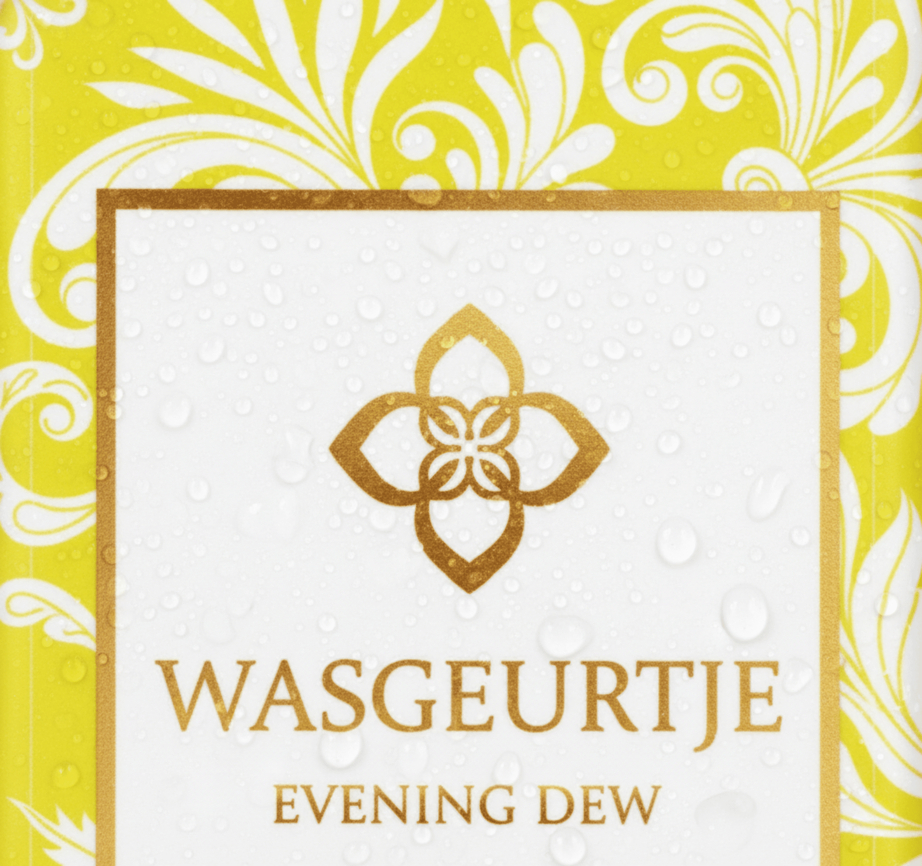 Close-up van het gouden label van Wasgeurtje Evening Dew wasparfum met dauwdruppels op het oppervlak — toont de premium afwerking en luxueuze uitstraling van het product.