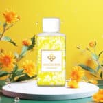 Wasgeurtje Evening Dew wasmiddel met een geel en wit sierlijk patroon en zomerse bloemen op een heldere achtergrond.