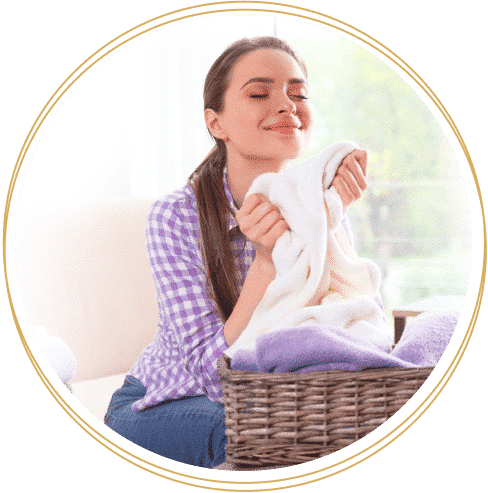 Vrouw geniet van de frisse geur van wasgoed met Wasgeurtje wasparfum