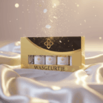 Luxe proefpakket van Wasgeurtje met vijf elegante flesjes wasparfum in een gouden verpakking. De set ligt op glanzende satijnen stof met fonkelende gouden lichtdeeltjes, en straalt een warme, premium uitstraling uit. Ideaal om alle vijf Wasgeurtje-geuren te ontdekken.
